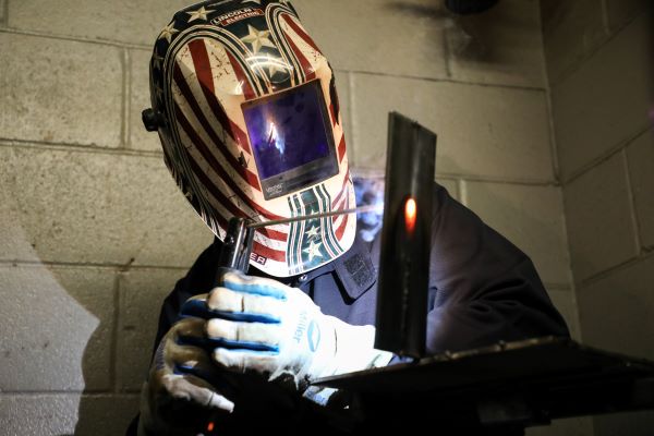 Student welding metal.