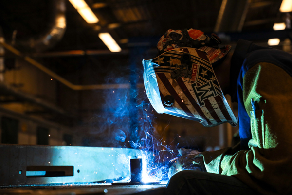 A student welding metal.