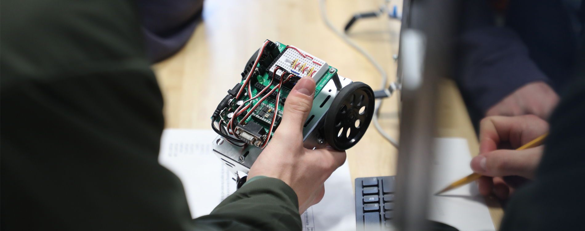 A student works with a robot at Tech Day