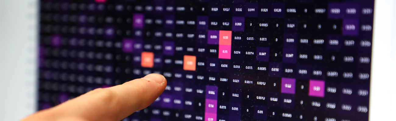 Hand pointing at various blocks of data on a computer monitor