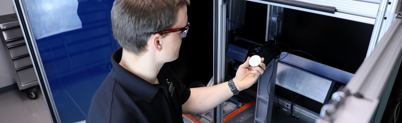 Mechanical engineering student examining metal