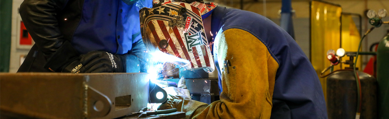 Student welding metal