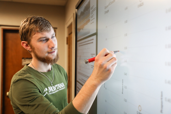 Student writing data on a smarboard