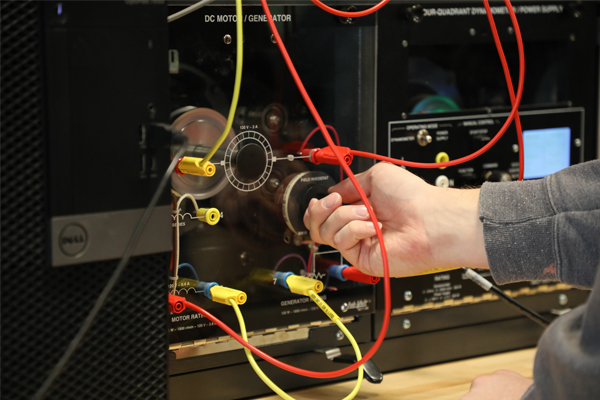 Hand turning a dial on electrical equipment