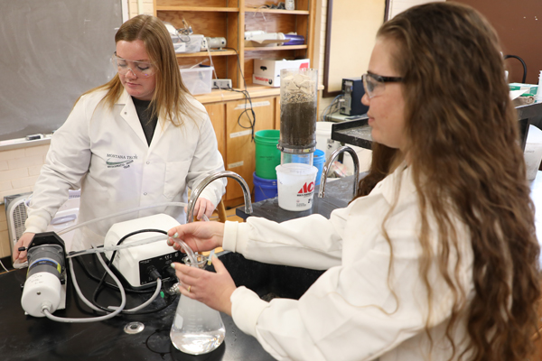 Two female students using environmental engineering lab equipment