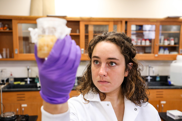 Woman holding a beaker containing fluid