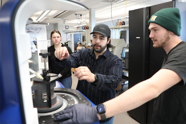 Mechanical engineering students using equipment in a lab