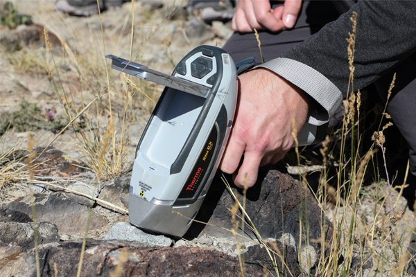 Hand holding a tool to examine rock samples