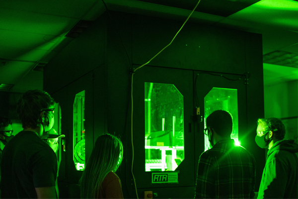 Students in a lab emitting green light