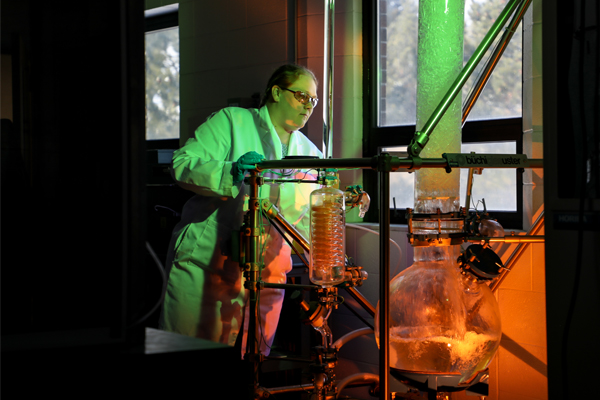 Student looking at a giant glass beaker