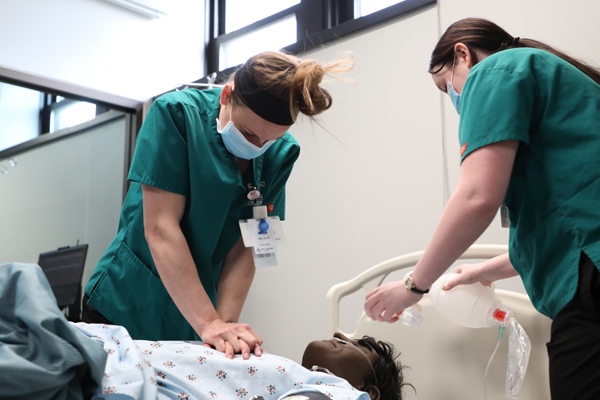 Nursing students performing CPR on a mannequin