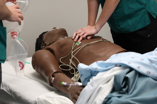 Nursing students performing respiratory procedures on a mannequin