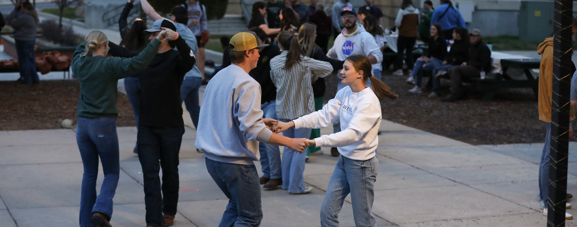 Group of people swing dancing on a courtyard.