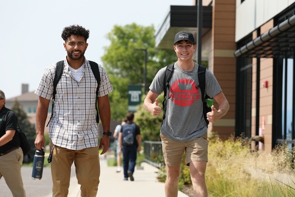Two students giving a thumbs-up.