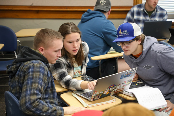 A group of students studying on a laptop.