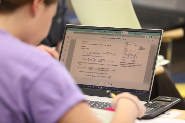 Student doing math problems on a laptop.