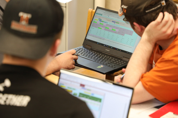 Students working on laptops in class.