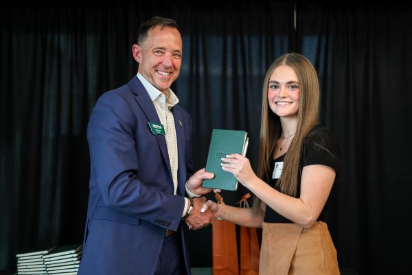 A student receives a scholarship from Chancellor Les Cook. 