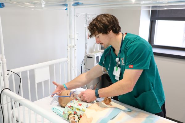 a student works with an infant mannequin