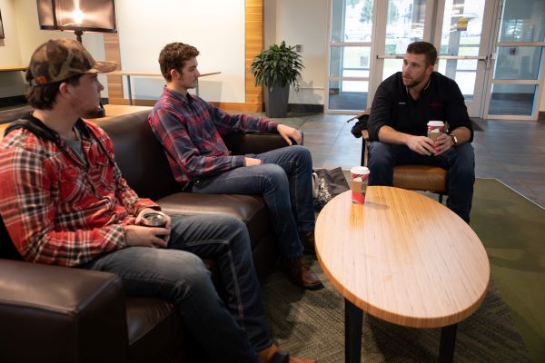 three men sit around a table