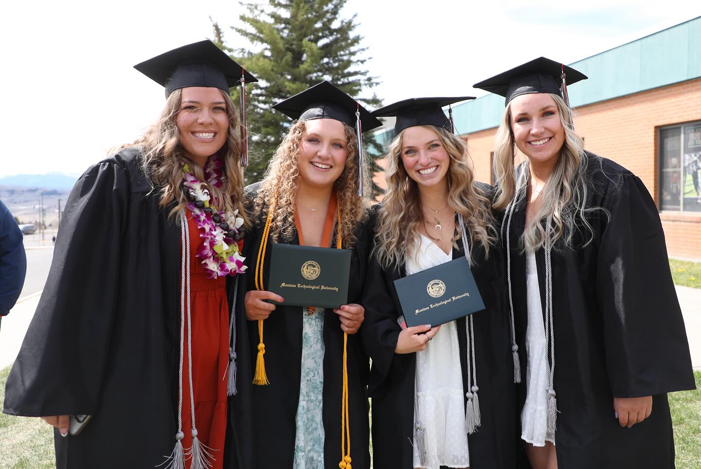 !graduates pose for a photo