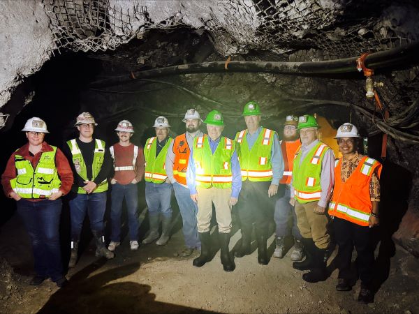 Richard Adkerson and Ryan Lance pose with students in the Underground Mine Education Center
