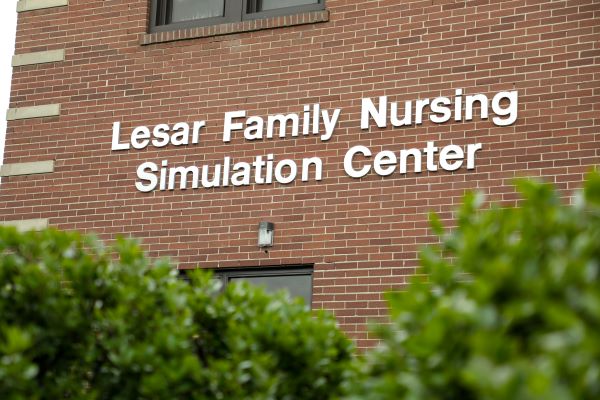 Signage on the side of a building that says 'Lesar Family Nursing Simulation Center'