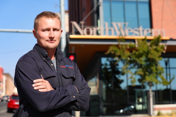 Nate Thompson stands in front of the NorthWestern Energy building
