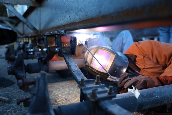 A welding student works on a trailer