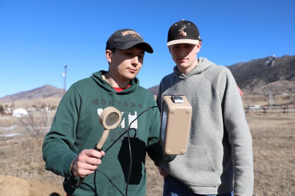 Two students measure radon in the field