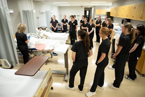 CNA students observe a demonstration with a dummy