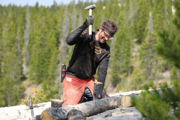 Daniel Kelly hammers a piece of wood into the ground