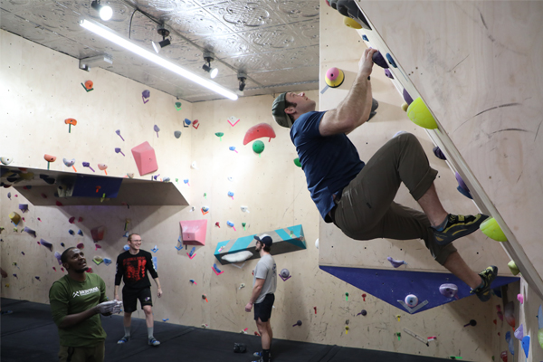 Group of men indoor rock climbing